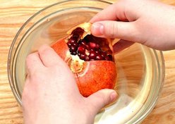While the pomegranate is under water, gently pull fruit apart into quarters.